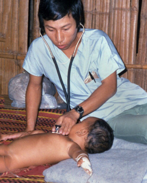 Sok Ry holds a stethoscope up to a baby's chest