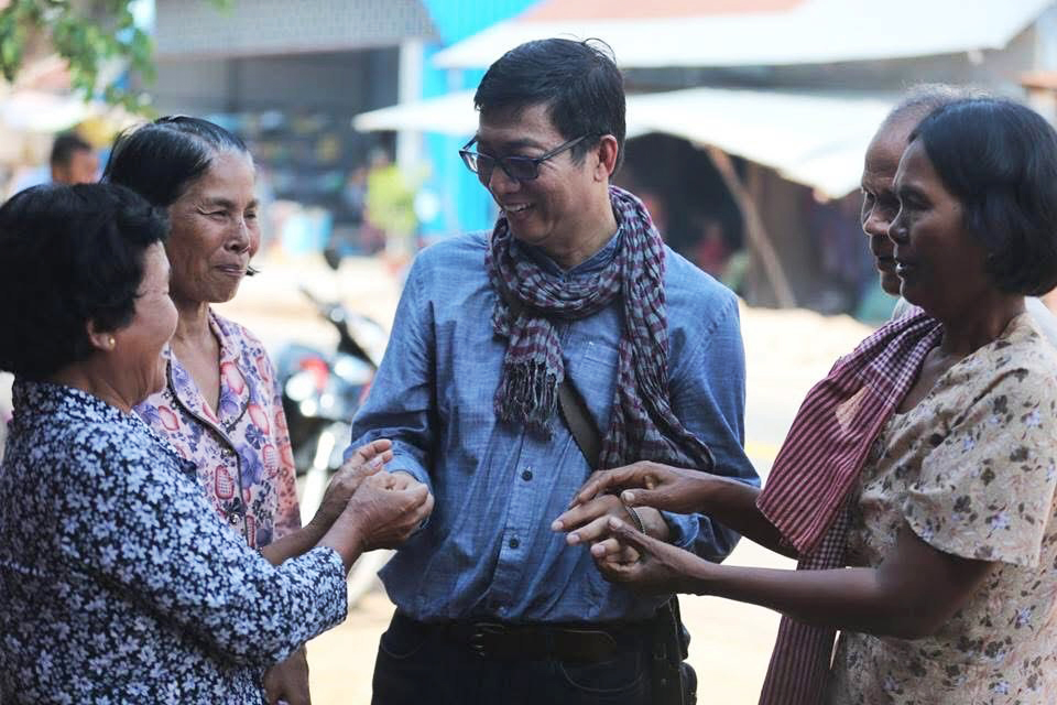 Vuthy shakes hands with a group of women