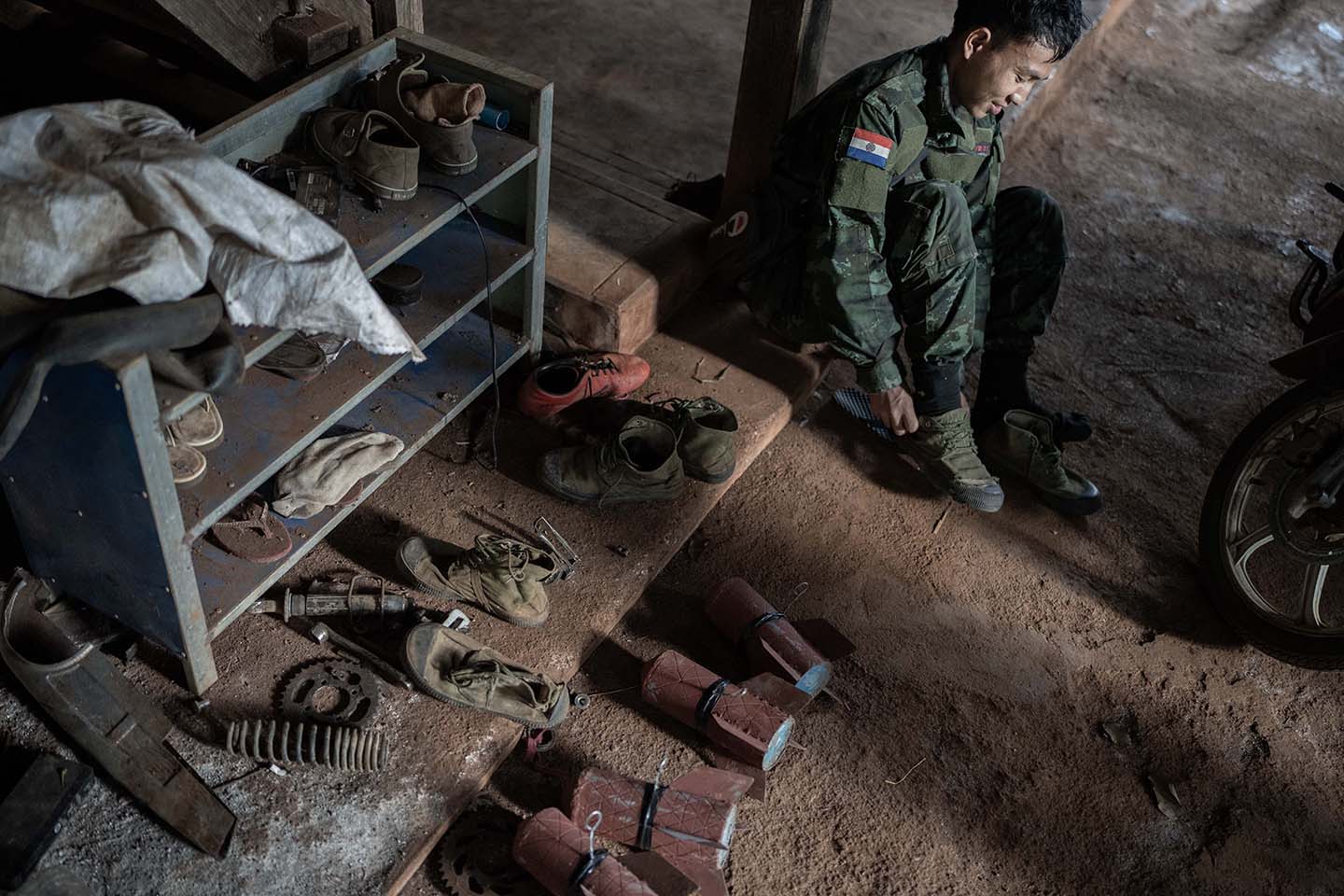 Fighter puts on shoes near a shoe rack and two bombs