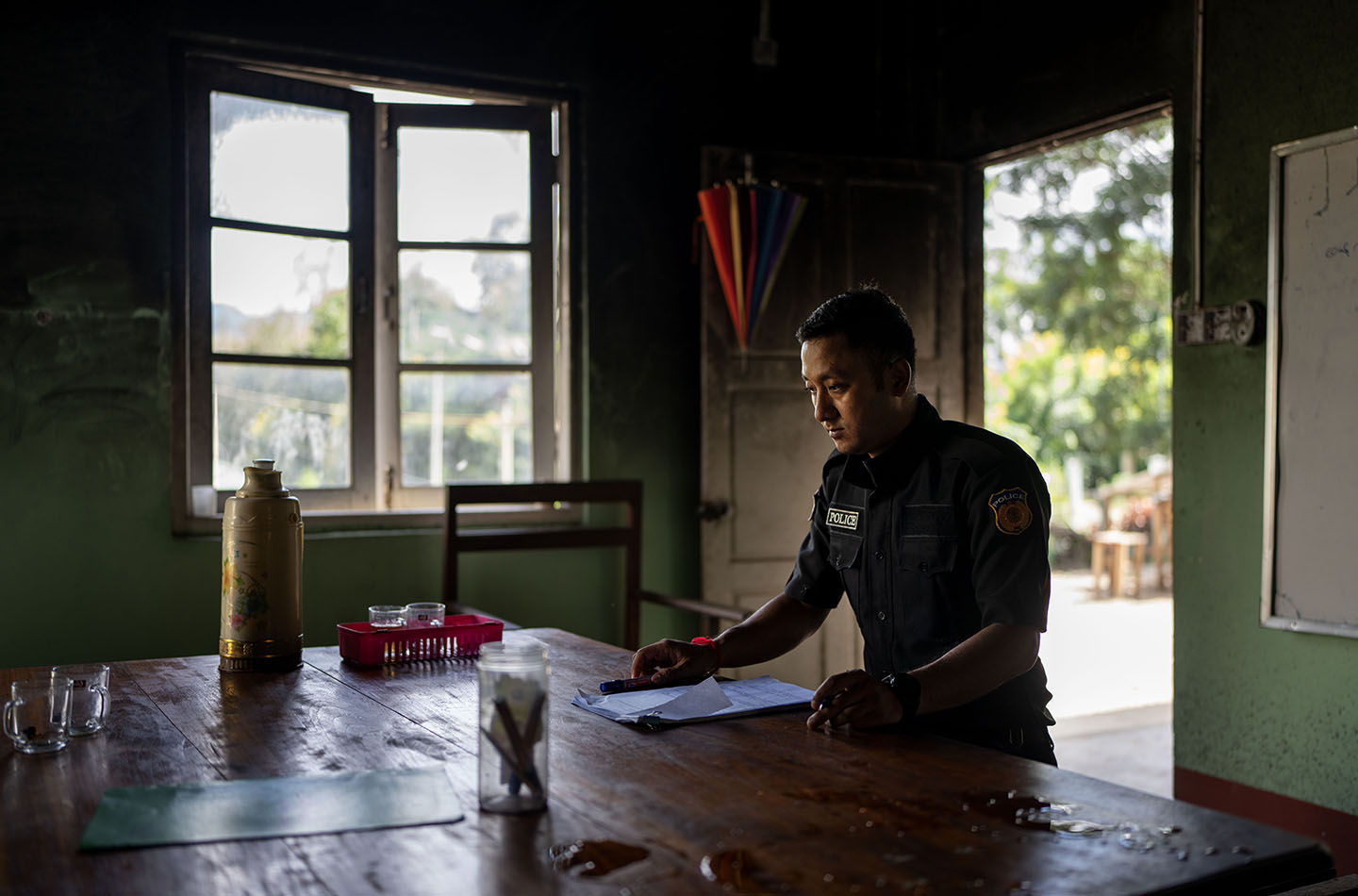 Man in uniform sits at a wooden desk