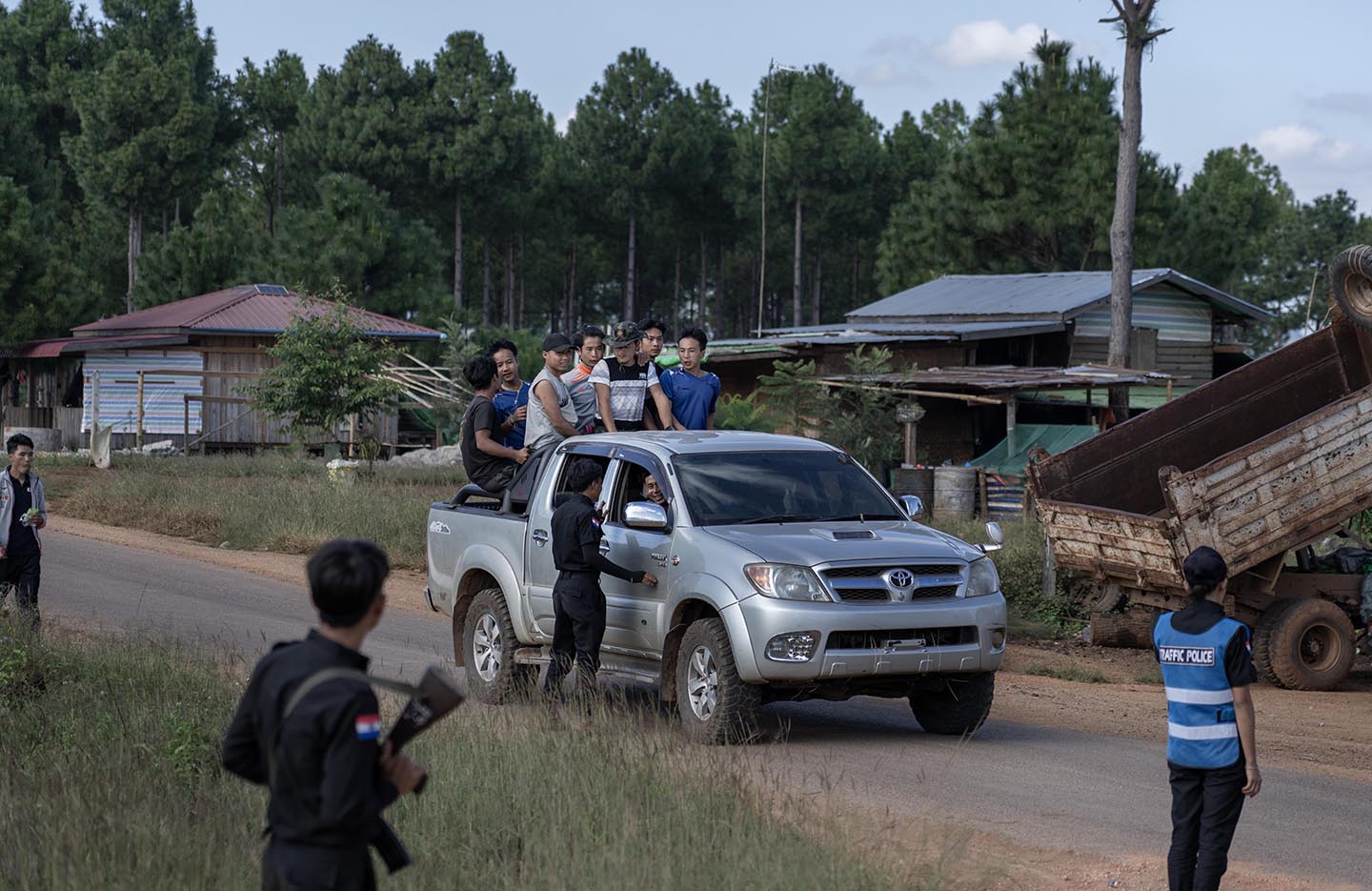 Group of people ride in the back of a truck as an officer talks to them