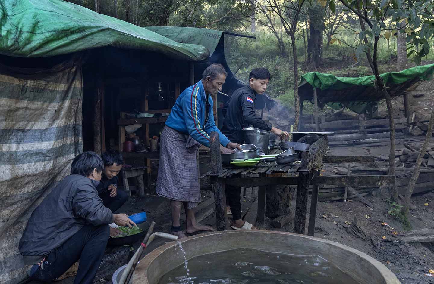 Detainee helps officer wash dishes outside of a tent