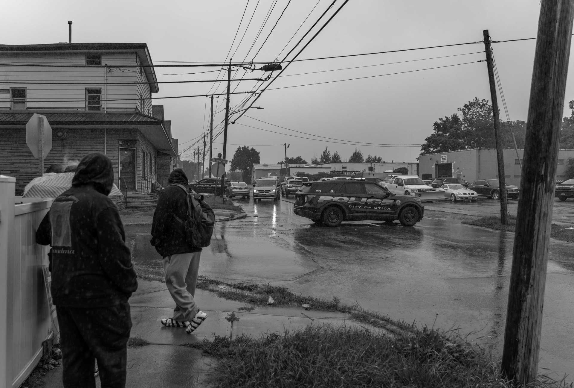 Officers from the Utica Police Department respond to an incident as neighbors watch on in Utica, New York, Aug. 19, 2024.