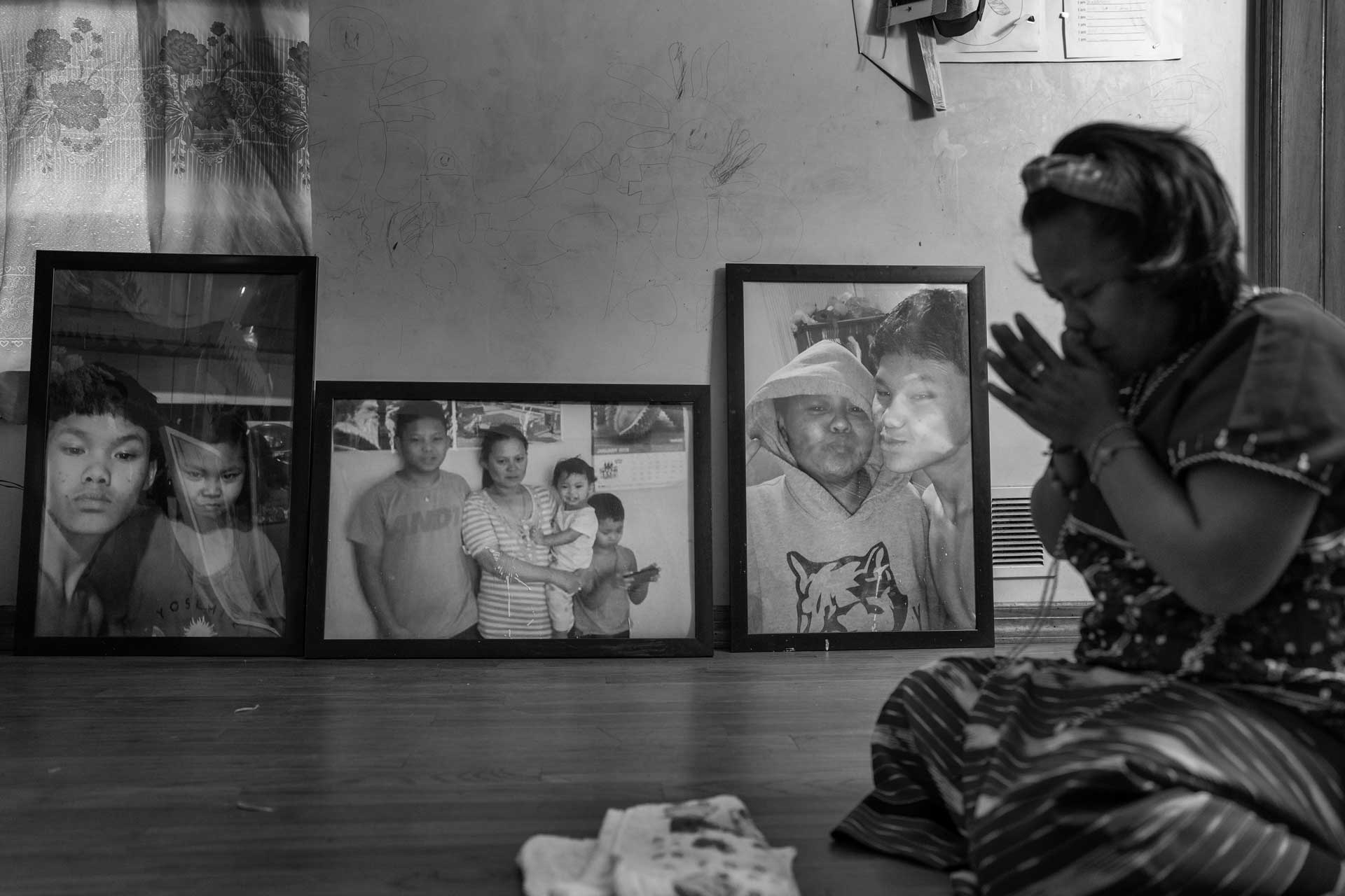 Chee Wwar prays at the Buddhist shrineBuddha statue inat their home, which is surrounded by pictures of her son Nyah Mway in Utica, New York, Aug. 17, 2024.