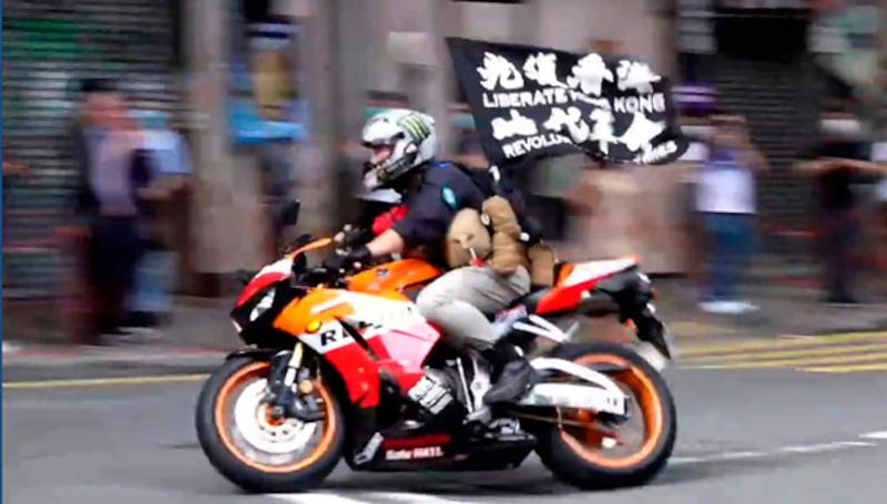 Motorcyclist Tong Ying-kit carries a flag reading 'Liberate Hong Kong, Revolution of our times' during a protest in Hong Kong on the anniversary of its return to China, July 1, 2020. (Cable TV Hong Kong via AP)