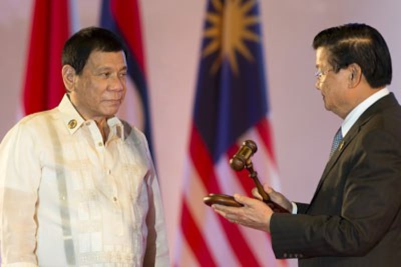 Thủ tướng Lào Thongsing Thammavong (phải) trao chiếc búa tòa cho Tổng thống Philippines Rodrigo Duterte (trái) trong lễ bế mạc Thượng đỉnh ASEAN bàn giao chức chủ tịch ASEAN cho Philippines tại Vientiane hôm 08 tháng 9 năm 2016. AFP