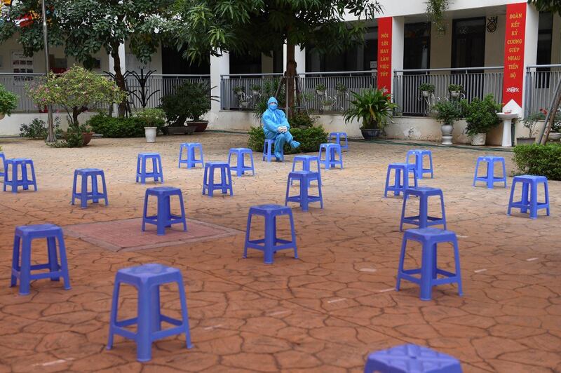 A health worker waits amidst empty stools at a Covid-19 coronavirus vaccination centre for youths between the age of 12 to 17 in Hanoi, Nov. 23, 2021. Credit: AFP