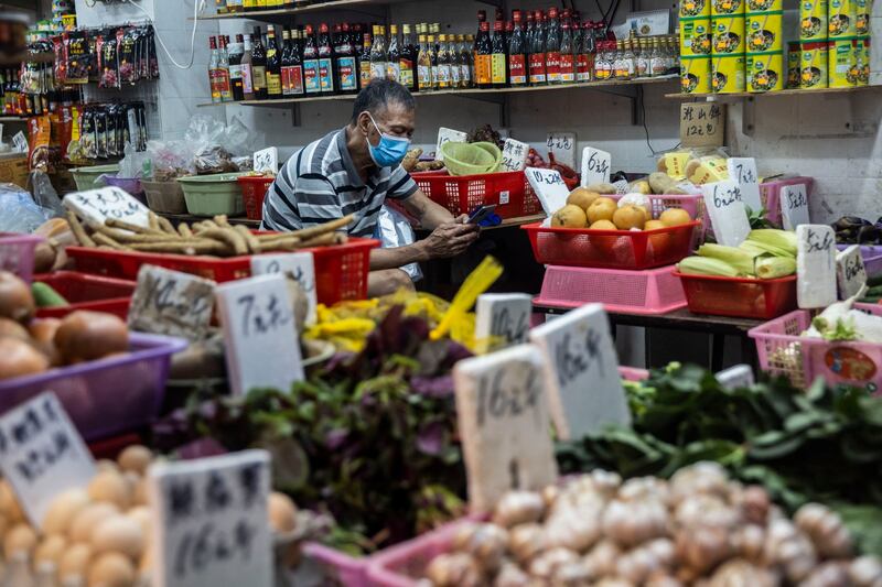 A man sits in a grocery store in Hong Kong, Sept. 30, 2022. (Isaac Lawrence/AFP)