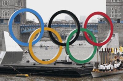 5 vòng tròn Olympic trên một chiếc xà lan nổi trên sông Thames ở phía trước cầu Tower trong quá trình chuyển tiếp ngọn đuốc thiêng Olympic hôm 27/07/2012 tại London. AFP photo/Will Oliver.