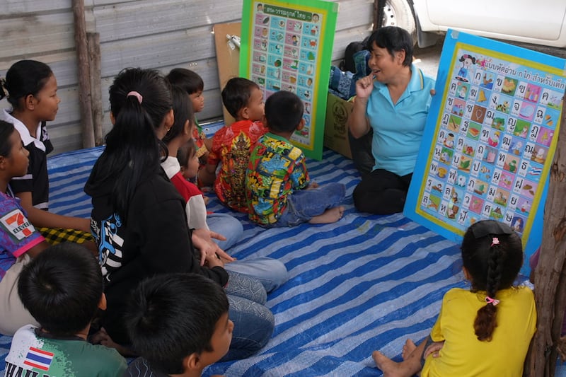 Volunteer Tongpul Buasri teaches Thai to migrant children at a construction camp in Samut Sakhon province, Thailand, Oct. 15, 2024.