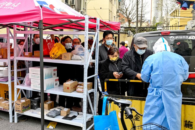 Residents are checked at the entrance of a residential area that is locked down in Shanghai, March 28, 2022. Credit: AFP