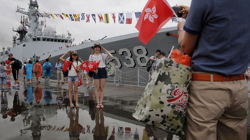 2017年7月8日，在香港昂船洲海军基地开放日，游客在解放军护卫舰烟台前摆姿势拍照，以纪念香港回归中国20周年。（美联社） 