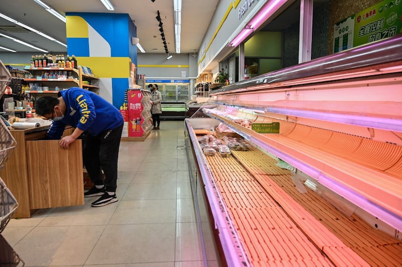 Shoppers rummage through empty shelves in a supermarket before a lockdown as a measure against the Covid-19 coronavirus in Shanghai, March 29, 2022. Credit: AFP