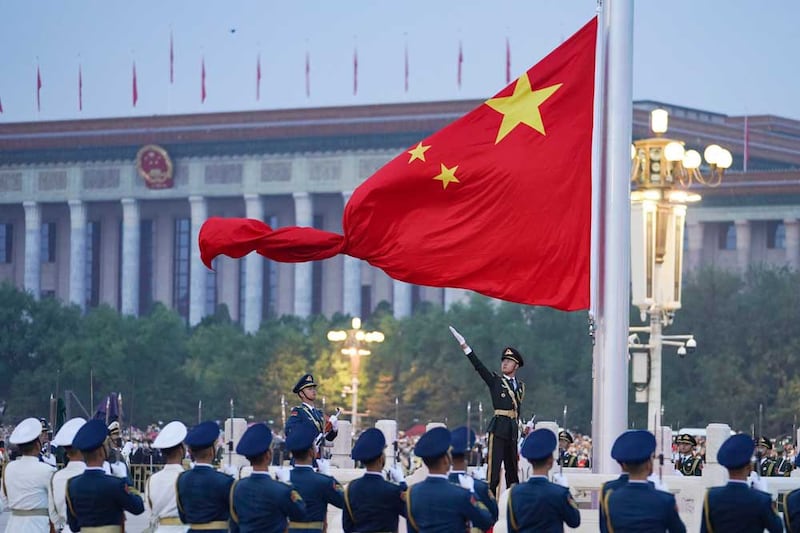 The Chinese national flag is unfurled at Tiananmen Square in Beijing on Saturday, Oct. 1, 2022, to mark the 73rd anniversary of the founding of the People's Republic of China. Journalist Sheng Xue says harassment picks up around these events. Credit: Chen Zhonghao/Xinhua via AP