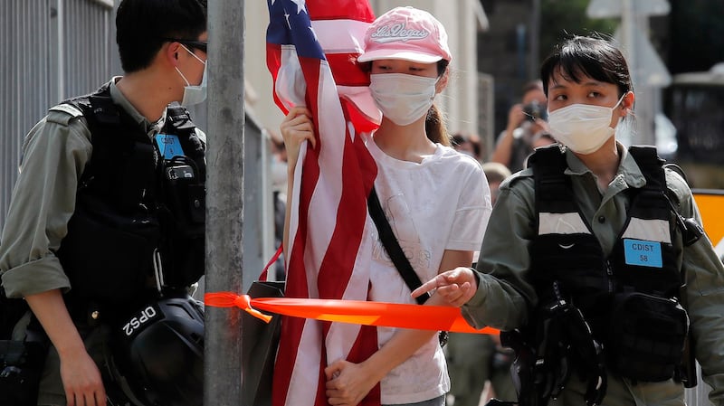 2020年7月4日，香港防暴警察拦阻一名举着美国国旗的香港抗议民众。（美联社）