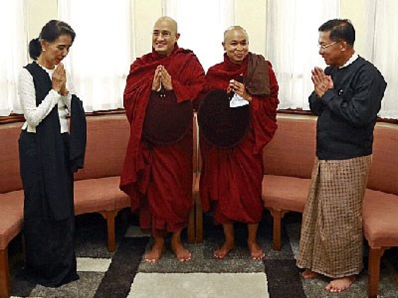 Myanmar's State Counselor Aung San Suu Kyi (L) and military commander-in-chief Senior General Min Aung Hlaing (R) pay their respects to two Buddhist monks to commemorate Martyrs' Day in Yangon, July 19, 2016.