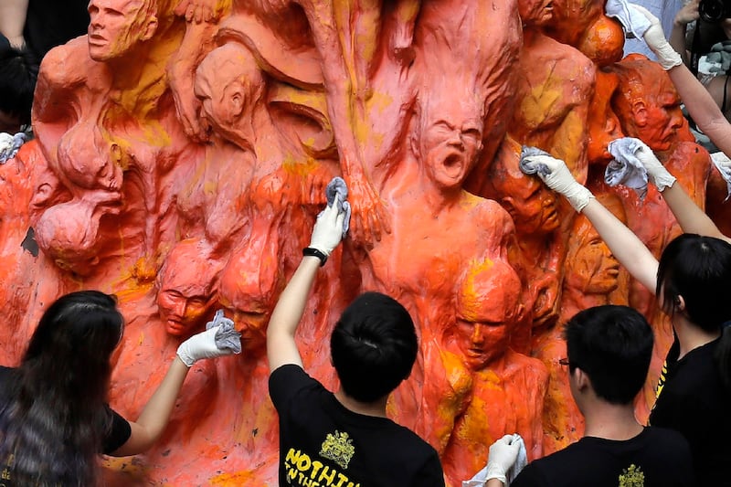 Students clean the "Pillar of Shame" statue at the University of Hong Kong, June 4, 2019. Credit: Kin Cheung/AP