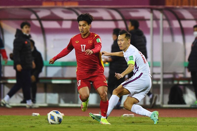 Vietnam's Vu Van Thanh (L) runs after the ball past China's Wu Xi during the FIFA World Cup Qatar 2022 qualifying round Group B football match between Vietnam and China at My Dinh National Stadium in Hanoi, Feb. 1, 2022. (Photo by Nhac NGUYEN / AFP)