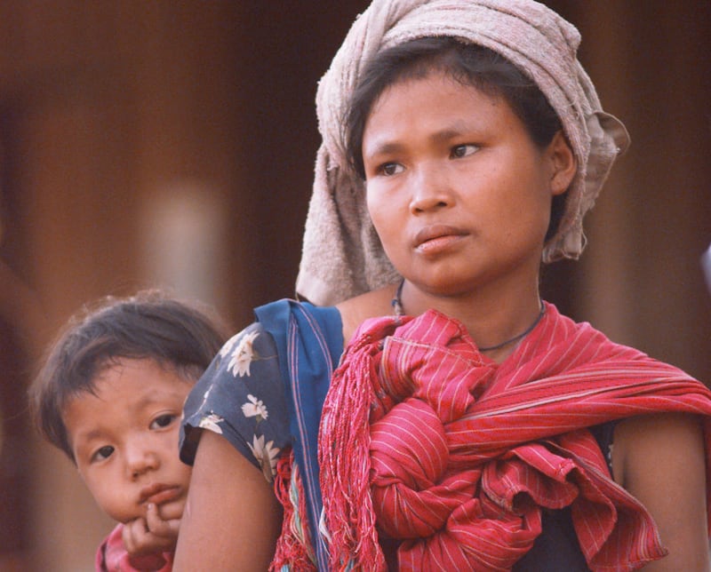 A young Karen baby eyes reporters as his mother talks about fleeing across the Thai-Burma border Saturday Feb. 16, 1997, near Nukathowa, Thailand. Karen refugees continue to seek safety in Thailand from Burmese Army attacks.  (AP Photo/David Longstreath)