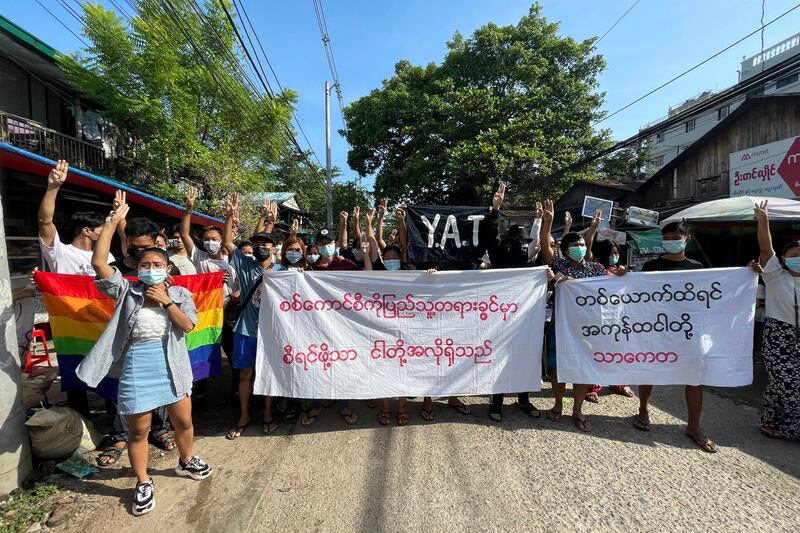 A small group of protesters against the military government that ousted Myanmar leader Aung San Suu Kyi earlier this year raise their hands with the three-finger protest gesture during a flash mob rally in Thaketa township in Yangon, Nov. 6, 2021. AP Photo