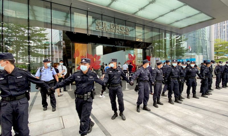 Security personnel form a human chain as they guard outside the Evergrande's headquarters, where people gathered to demand repayment of loans and financial products, in Shenzhen, Guangdong province, Sept. 13, 2021. Credit: Reuters