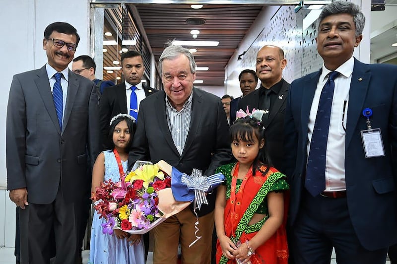 Bangladesh Foreign Affairs Adviser Md. Touhid Hossain, left, joined by other officials and two girls, welcome U.N. Secretary-General António Guterres, center, at the Hazrat Shahjalal International Airport in Dhaka, March 13, 2025.