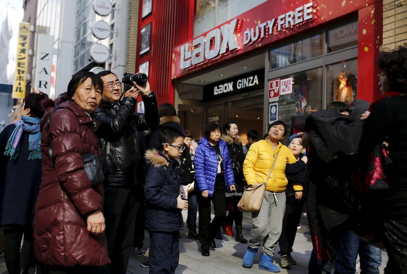 Chinese tourists stand outside a tax free department store in Tokyo, Feb. 4, 2016. (Thomas Peter/Reuters)