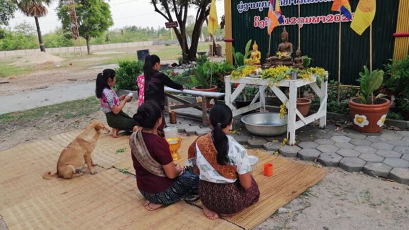 Women quietly honor Buddha during the Lao New Year outside a closed temple in Baan village, Songkhone District. in southern Laos' Savannakhet province, April 2020.