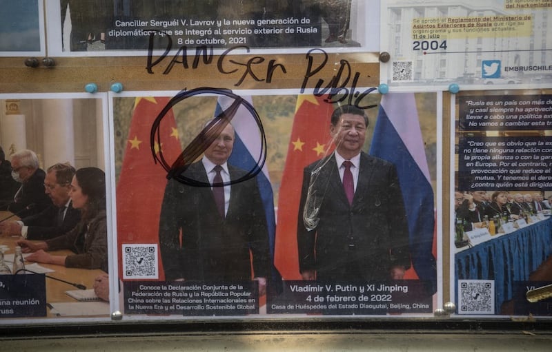 A photo of Russian President Vladimir Putin and his Chinese counterpart Xi Jinping at the Russian Embassy in Santiago, Chile is defaced in a protest in support of Ukraine, February 26, 2022. Credit: AFP