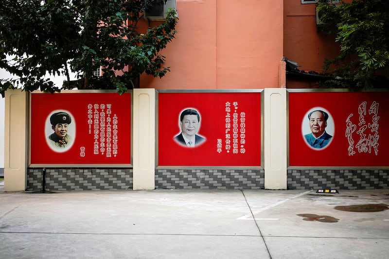 Pictures of late People's Liberation Army soldier Lei Feng, Chinese President Xi Jinping and late Chinese Chairman Mao Zedong overlook a courtyard in Shanghai, China, September 26, 2017.