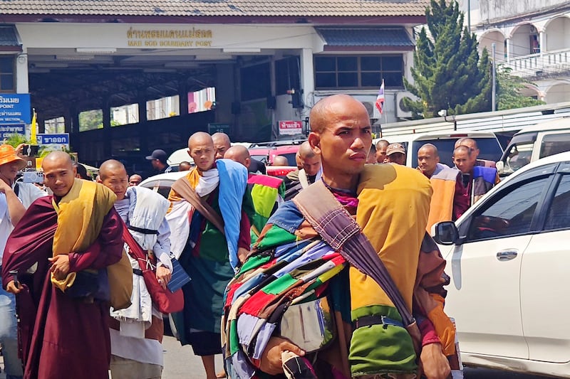 Buddhist monks are turned back at the Mae Sot border gate, background, between Thailand and Myanmar, March 4, 2025.