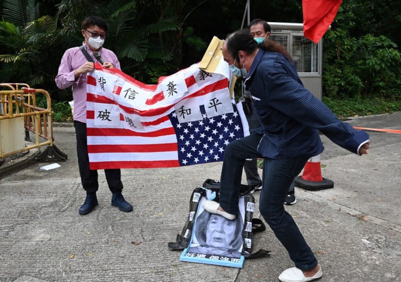 A pro-Beijing protester stamps on an image of U.S. House Speaker Nancy Pelosi during a protest outside the U.S. Consulate in Hong Kong, Aug. 3, 2022. Credit: AFP