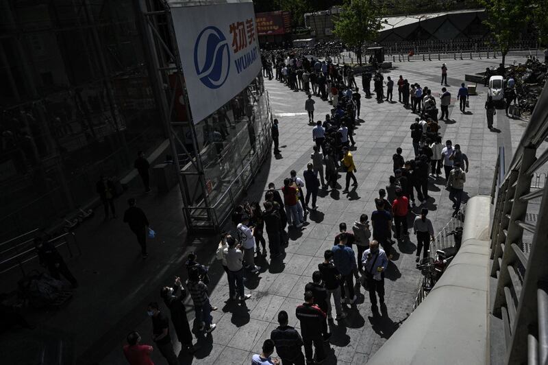 People line up to be tested for Covid-19 coronavirus outside a supermarket in Beijing on April 26, 2022, the day the Chinese capital launched mass coronavirus testing for nearly all its 21 million people. Credit: AFP