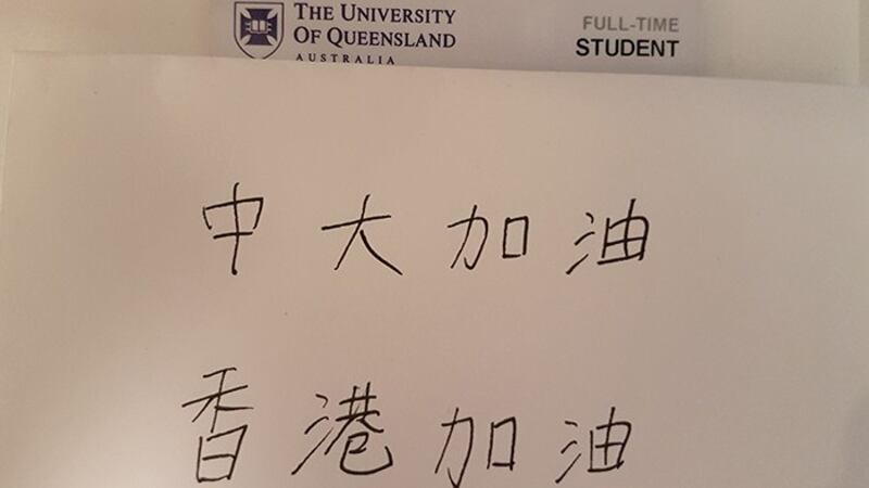 澳大利亚昆士兰大学网友展示出所属学校的证件，并附上写有“中大加油、香港加油”等字句。（品葱网）