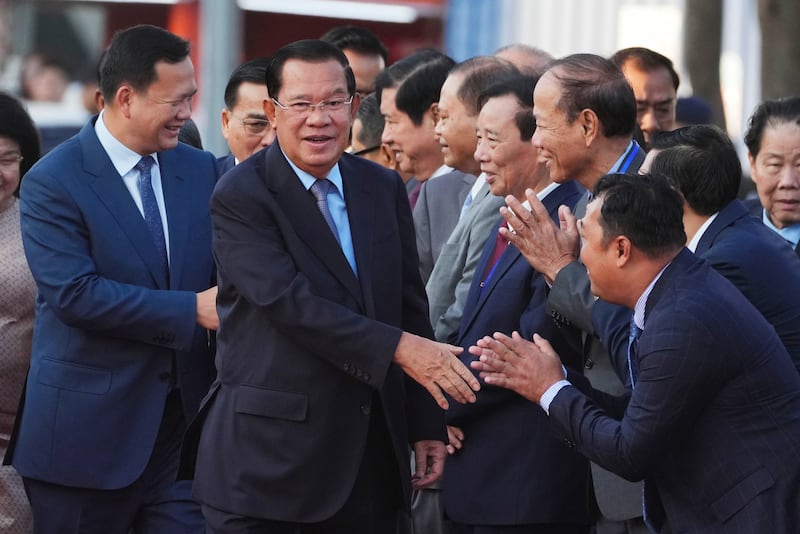 Cambodian President of the Senate Hun Sen, center, and his son and Prime Minister Hun Manet, left, greet senior officials as they arrive at Victory Day to mark the 46th ouster anniversary of the Khmer Rouge regime that ruled Cambodia from 1975 to 1979, in Phnom Penh, Cambodia, Tuesday, Jan. 7, 2025. (AP Photo/Heng Sinith)