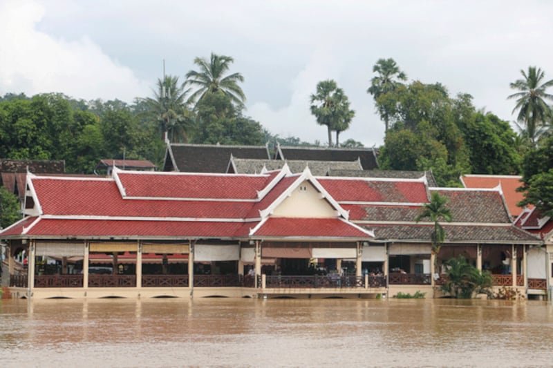 People gather on a porch as buildings sit in floodwaters in Luang Prabang province, Laos, Sept. 12, 2024. (FB/Pouth Freedomman via Reuters)