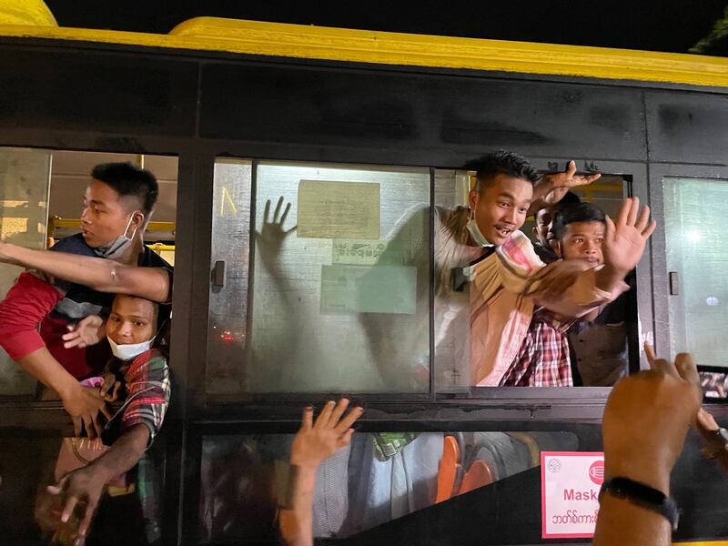 Prisoners aboard a bus wave to loved ones after exiting Insein Prison in Yangon, Oct. 18, 2021. RFA