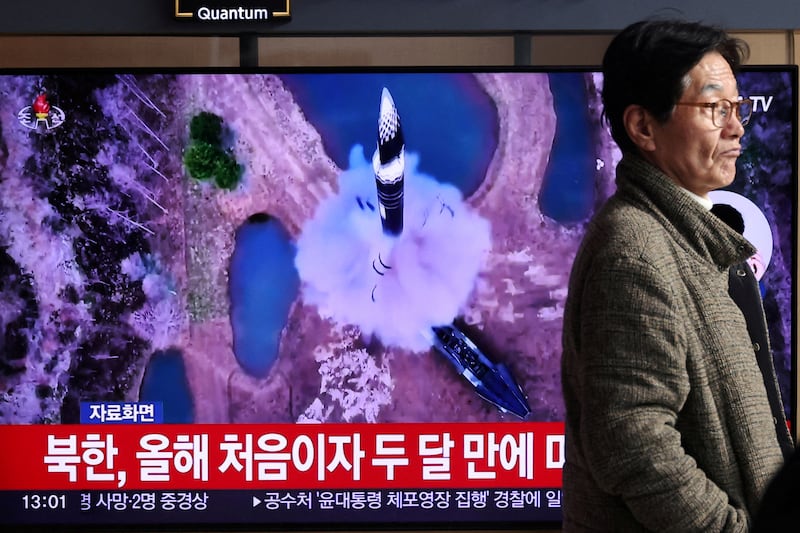 A man in Seoul walks past a screen showing a news report on North Korea firing a ballistic missile Jan. 6, 2025.