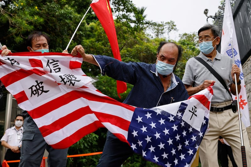 Pro-China supporters tear a U.S. flag during a protest against U.S. House of Representatives Speaker Nancy Pelosi's visit to Taiwan outside the Consulate General of the United States in Hong Kong, China, August 3, 2022. Credit: Reuters