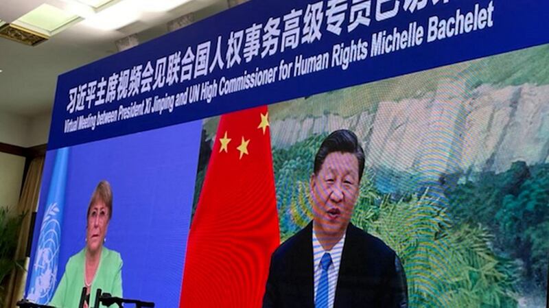 This handout image taken and released on May 25, 2022 by the Office of the United Nations High Commissioner for Human Rights (OHCHR) shows a screen of UN human rights chief Michelle Bachelet (L) attending a virtual meeting with China's President Xi Jinping, in Guangzhou. Credit: AFP