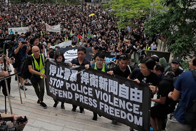 2019年7月14日，数百名香港记者发起“停止警暴、捍卫新闻自由”静默游行。（美联社）