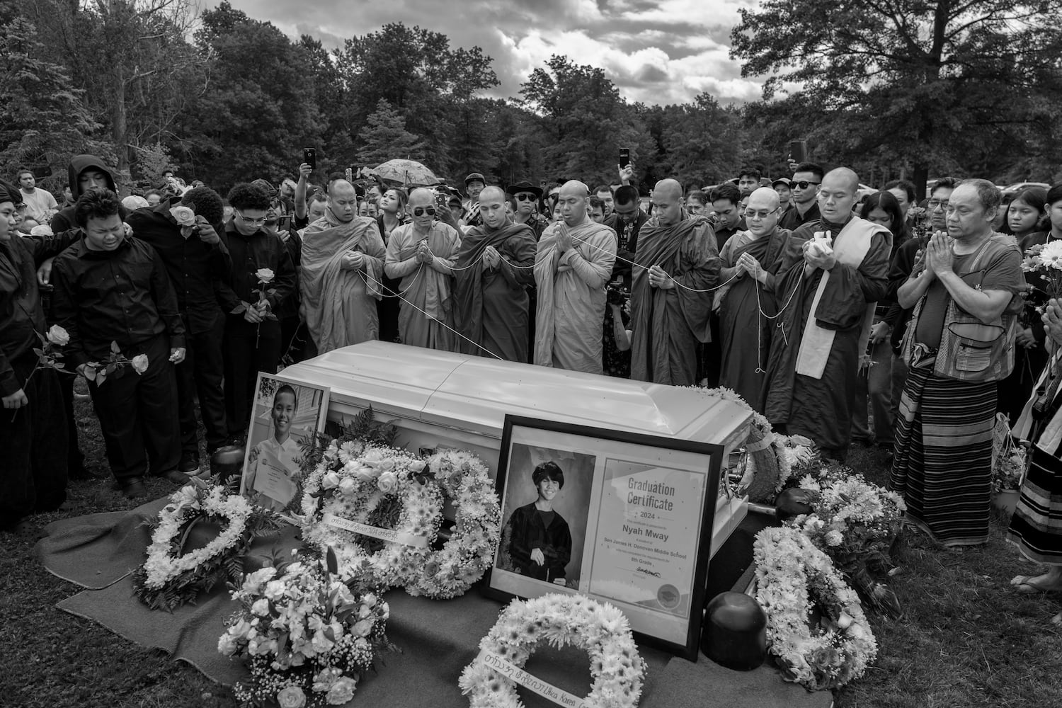 Buddhist monks chant at the burial of Nyah Mway, 13, in Utica, New York, July 6, 2024.