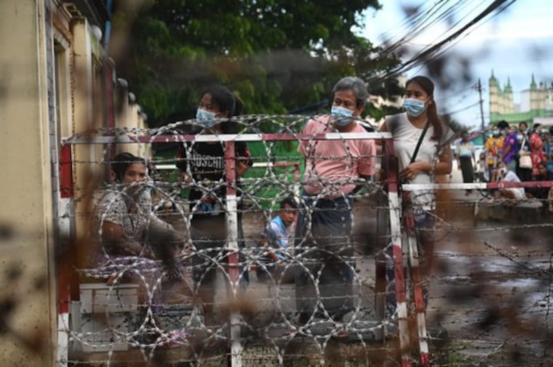 People wait outside Insein Prison in Yangon as the military authorities announced that more than 5,000 people jailed for protesting against a February coup, which ousted the civilian government, would be released, in Myanmar, Oct. 18, 2021. Credit: AFP