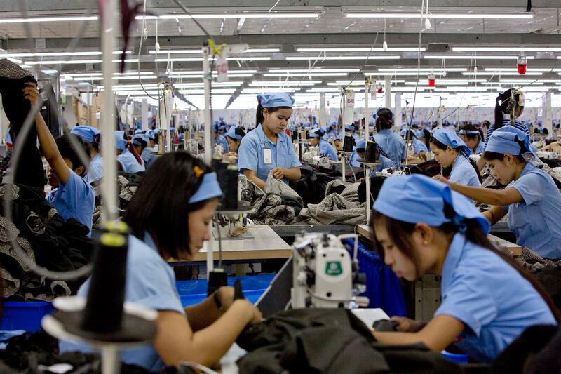 In this Sept. 29, 2015, file photo, workers in the Great Forever factory stitch clothes in the Hlaing Tharyar industrial zone outside Yangon, Myanmar.