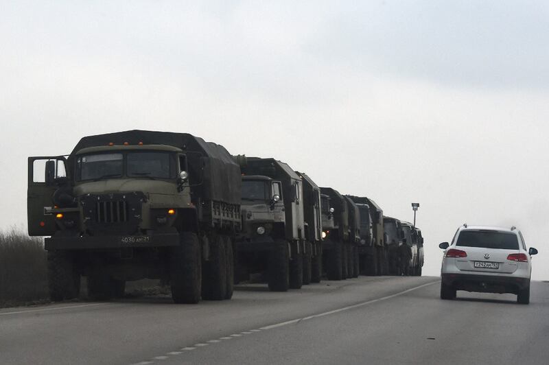 Russian military trucks and buses are seen on the side of a road in Russia's southern Rostov region, which borders the self-proclaimed Donetsk People's Republic, Feb. 23, 2022. Credit: AFP