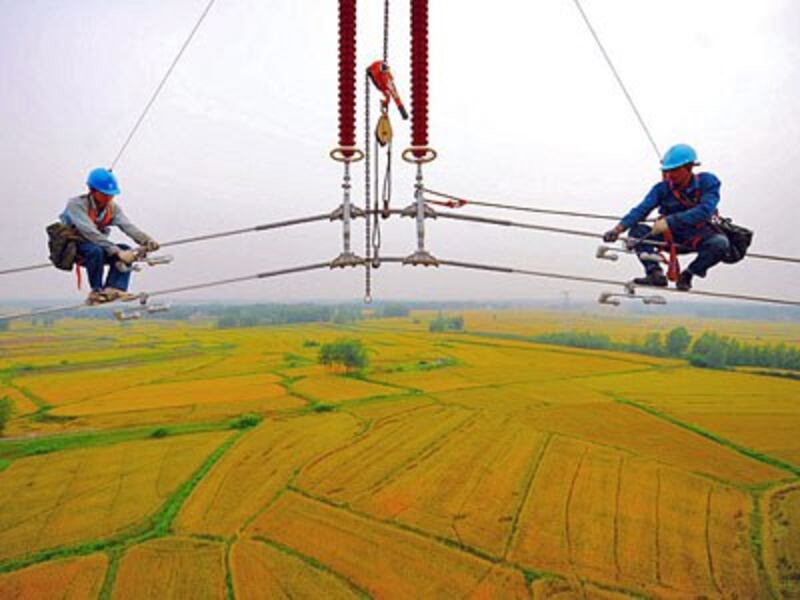 Chinese workers mount high-voltage cables over massive fields in Fengyang county of Chuzhou city in eastern China's Anhui province, May 22, 2014. 