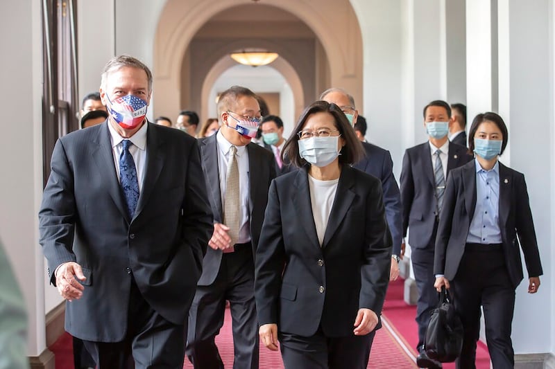 Former U.S. Secretary of State Mike Pompeo, left, and Taiwan's President Tsai Ing-wen, center, walk together during a meeting at the Presidential Office in Taipei, Taiwan, March 3, 2022. Credit: Taiwan Presidential Office via AP