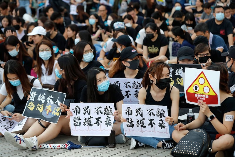 2019年8月2日，香港一批医疗界人士举行集会，示威者举着“公民不离，医护不弃”等标语。（美联社） 