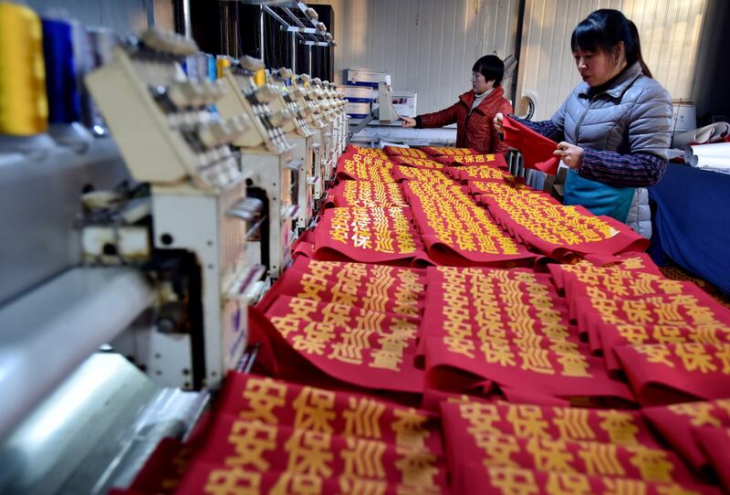 Workers make armbands reading "security patrol" at a garment factory in Zhangjiakou, Hebei province, China, Dec. 5, 2018. Credit: Reuters