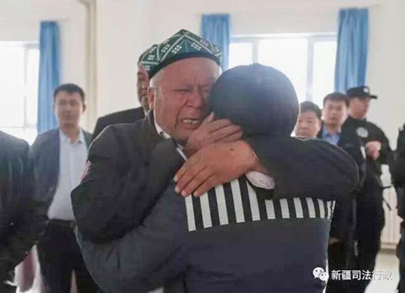 In a photo released by the Xinjiang Judicial Administration in 2018, a Uyghur father tells his son to confess his 'thought crimes' and to follow the Chinese Communist Party for lenient treatment. (Xinjiang Judicial Administration)